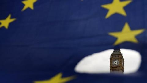 Big Ben is seen through a hole in an EU flag in London. Photo: 29 March 2017